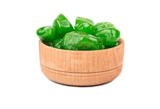 Dried green kumquat in a wooden bowl isolated on white background