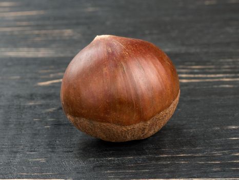 Fresh edible chestnuts on a wooden background