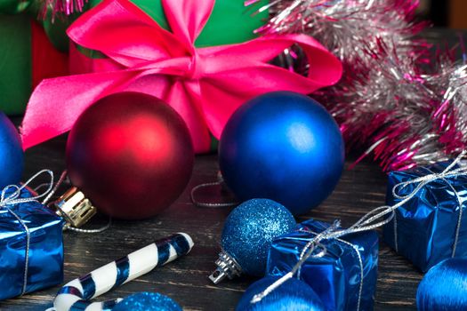 Red and blue Christmas ball with decorations on wooden background closeup