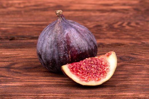Fresh figs with a slice cut on a wooden table