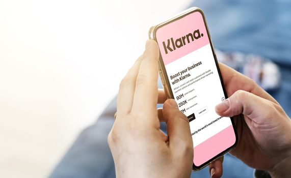 San Francisco, CA, US, July 2022: Female hands holding a phone with Klarna company web page on screen. Klarna is the largest private fin-tech start-up in Europe. Illustrative editorial