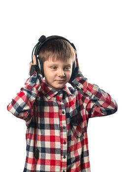 Portrait of a little boy listening to music in headphones on a white background