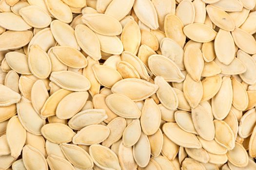 Background of roasted pumpkin seeds in a shell close up