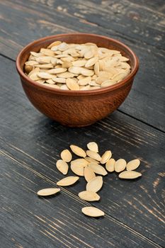 Pumpkin seeds in a shell in a ceramic bowl on the table