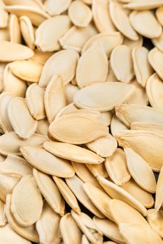 Background of roasted pumpkin seeds in a shell close up