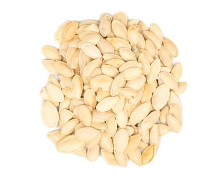 Bunch of roasted pumpkin seeds in a shell on a white background, top view