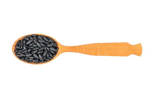 Black beans in wooden spoon on white background, top view