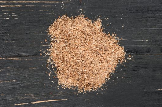 Bunch of nutmeg powder on wooden background, top view