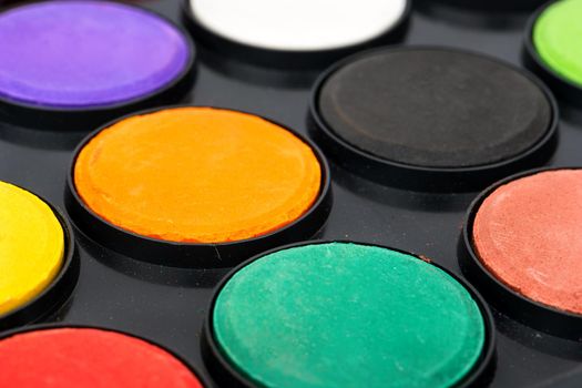 Plastic palette with colorful paints close up