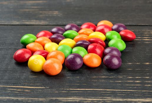 Delicious multicolored candy closeup on wooden background