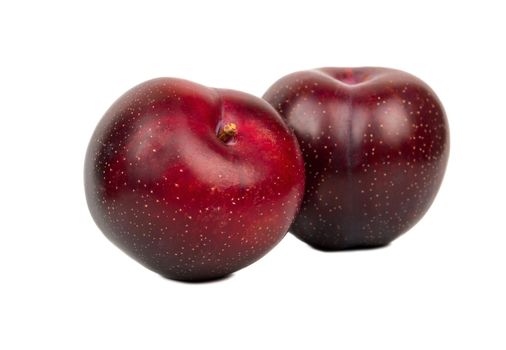 Two ripe big red plums isolated on white background