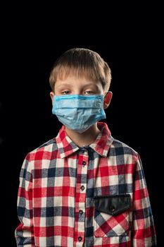 Sick boy in a face mask on a black background