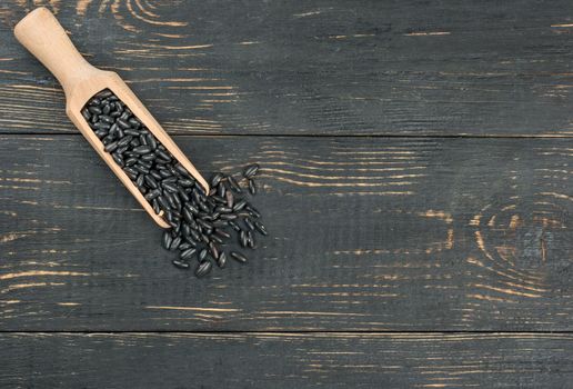 Scoop of black beans on an empty wooden background