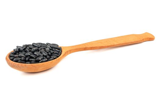 Wooden spoon with black beans isolated on white background