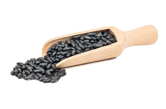 Wooden scoop with black beans isolated on white background