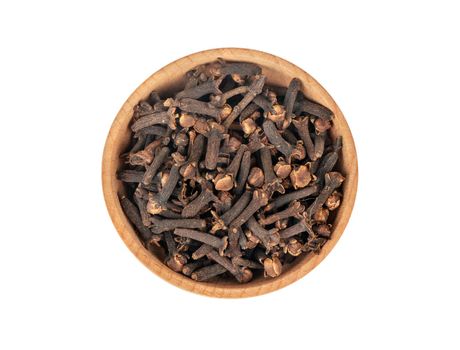 Dry cloves in wooden bowl isolated on white background, top view