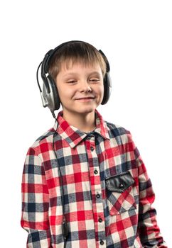 Portrait of a little boy listening to music in headphones on a white background