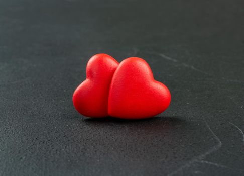 Two plastic hearts symbolizing Valentine's day on a dark background