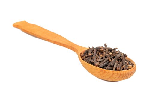 Wooden spoon with dry spice cloves on white background closeup