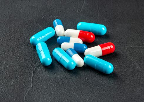 Scattered colorful capsules on a concrete background