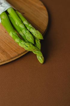 branches of fresh green asparagus on a wooden background, top view