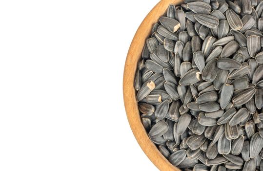 Part of a bowl with sunflower seeds on a white background, top view