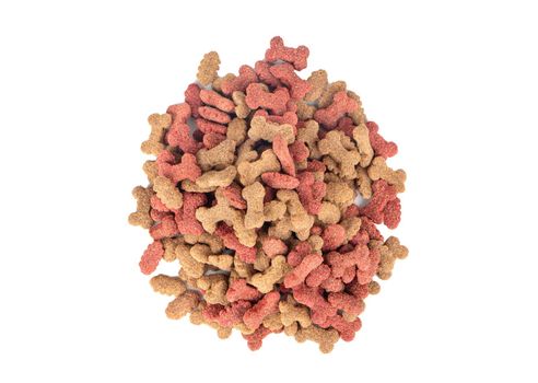 Pile of dry dog food in the shape of a bone on a white background, top view