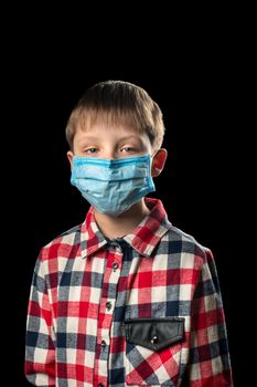 Sick boy in a medical mask on a black background