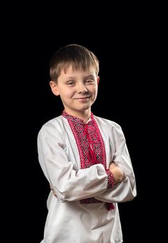 Beautiful boy in a white traditional Ukrainian shirt on a black background