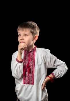 Beautiful boy in a white traditional Ukrainian shirt on a black background