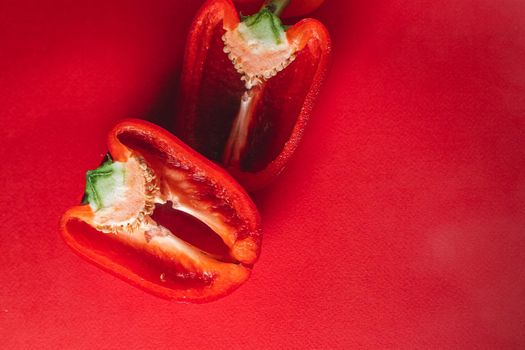 SWEET, fresh RED PEPPER ON A RED BACKGROUND, cut in half. photo for the menu, proper nutrition. fresh vegetables.