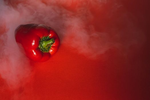 SWEET, fresh RED PEPPER ON RED BACKGROUND With smoke around, pepper. photo for the menu, proper nutrition. fresh vegetables.