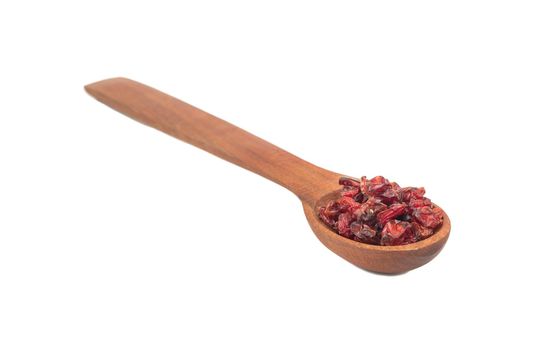 Dry red barberry in wooden spoon isolated on white background