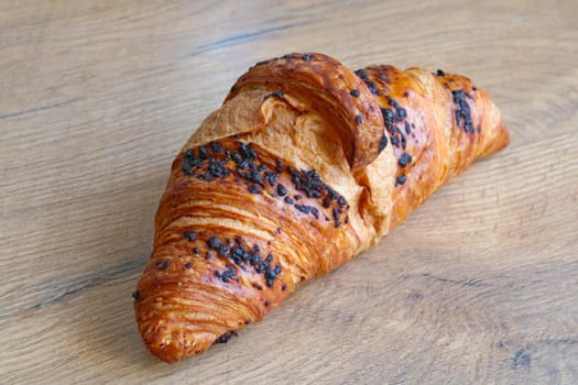 Fresh croissant on a wooden background. Baking for tea