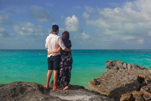 A man and a woman walk on the seashore.