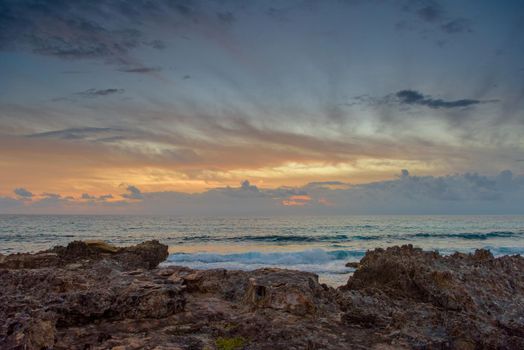 The coastline of the Caribbean Sea with white sand and rocks in Cancun.