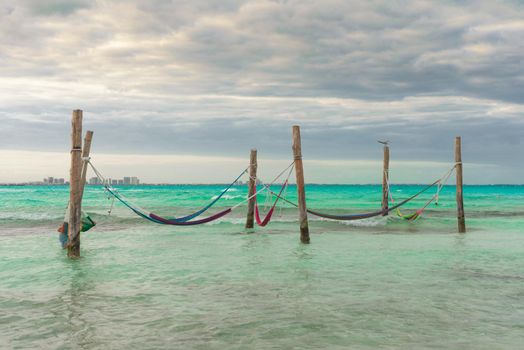 Hammocks hang on poles in the Caribbean.