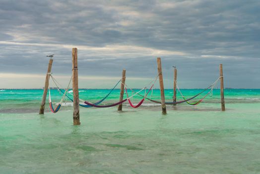 Hammocks hang on poles in the Caribbean.