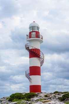 Lighthouse on a rocky shore in Cancun. Clear sky and blue sea.