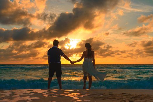 Silhouettes of men and women against the backdrop of the setting sun