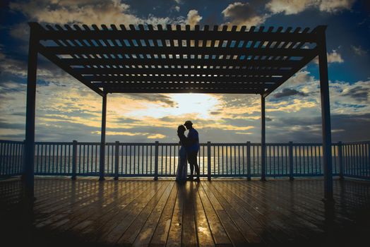 Silhouettes of men and women against the backdrop of the setting sun