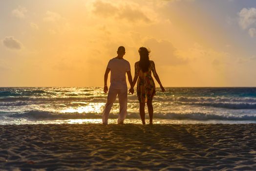 Silhouettes of men and women against the backdrop of the setting sun