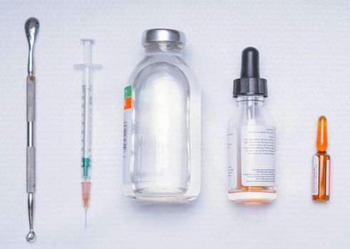 Medical ampoules, drugs and syringe on light backgroung, medicine concept