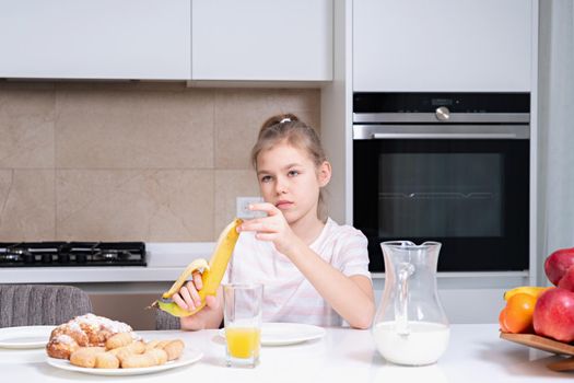 Pretty girl eating breakfast in the kitchen before school