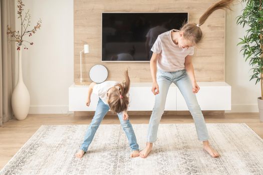 Two sisters having fun dancing in living room