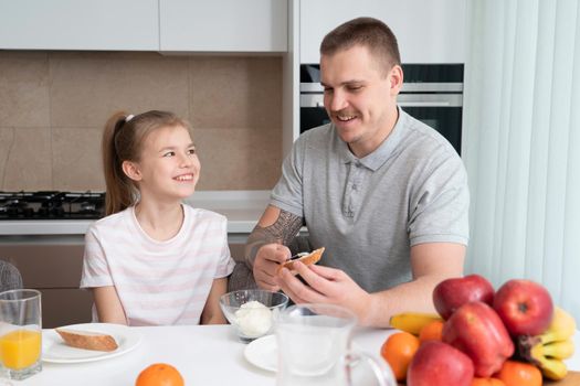 Father and daughter eating breakfast at kitchen