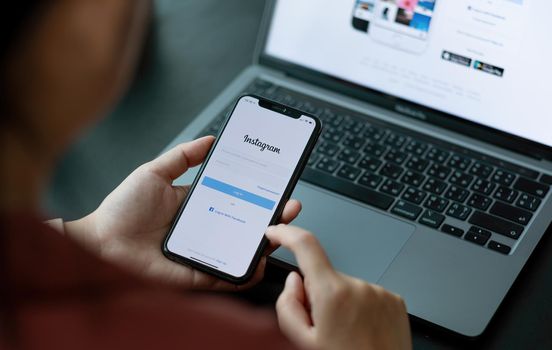 CHIANG MAI, THAILAND - APR 10, 2021: A woman holds Apple iPhone X with Instagram application on the screen. Instagram is a photo-sharing app for smartphones.