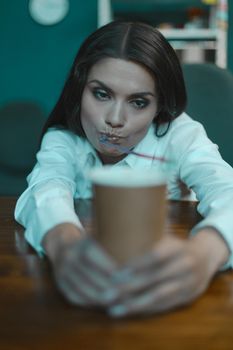 Tired young business woman drinks coffee. Bored woman at office workplace. Crisis concept. Tinted image.