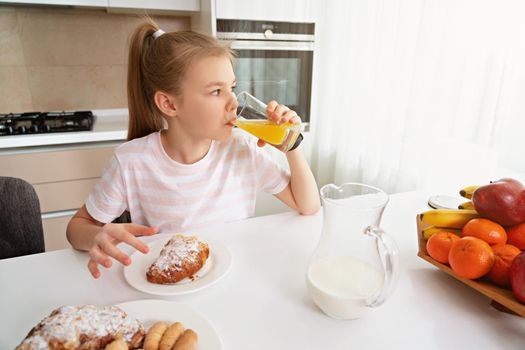 Pretty girl eating breakfast in the kitchen before school