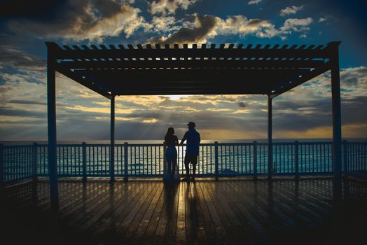 Silhouettes of men and women against the backdrop of the setting sun